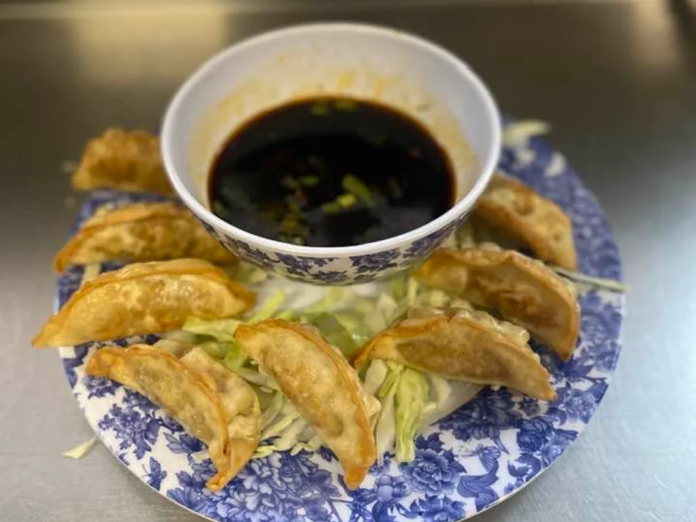 Fried dumplings arranged around a bowl of dipping sauce at Shanghai Town